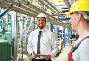 portrait smiling engineer with worker in a modern industrial plant