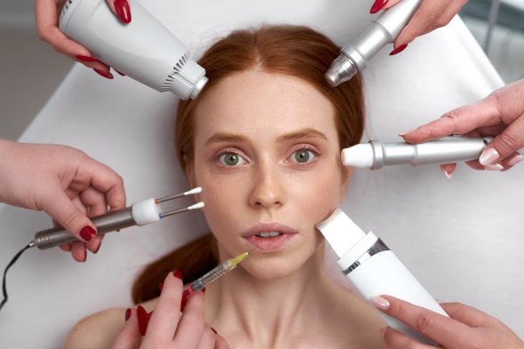 several beauticians holding their equipment near female face several beauticians holding their equipment near female face