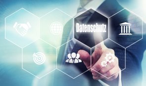 A businessman pressing a Data Protection "Datenschutz" button in German on a futuristic computer display A businessman pressing a Data Protection "Datenschutz" button in German on a futuristic computer display