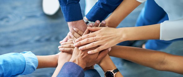 Lets awaken the team spirit. High angle shot of a group unrecognizable businesspeople joining their hands together in unity.