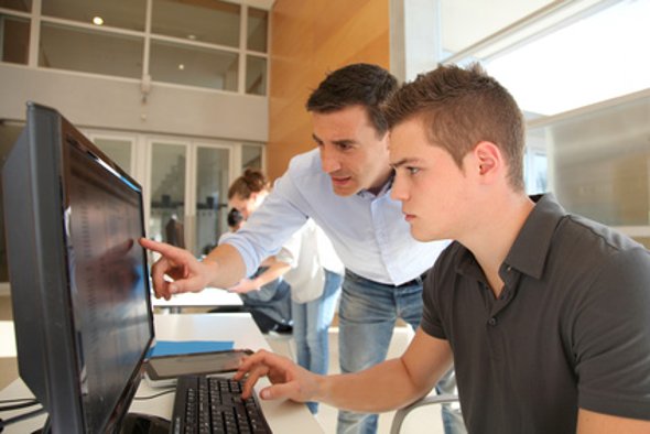 Lehrer und Schüler im Unterricht am Computer