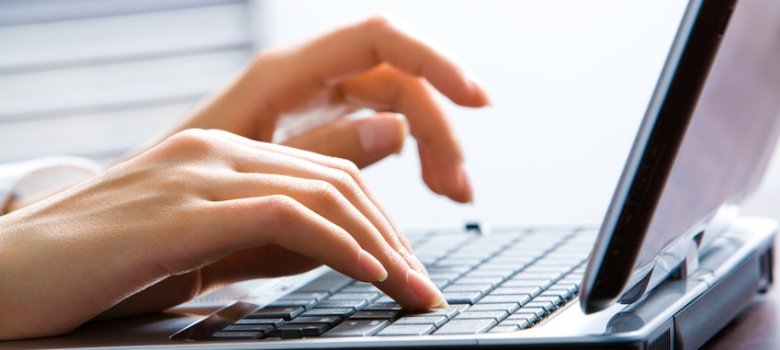 Image of female hands on the keys typing documents
