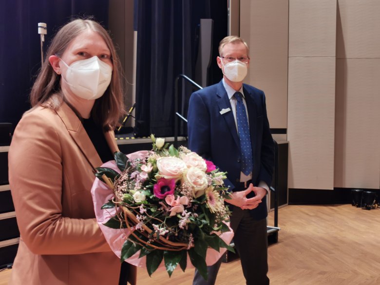 Kreisdirektorin Susanne Koch mit Blumen in der Hand. Neben ihr steht Landrat Sven-Georg Adenauer. 