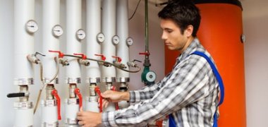 Heizungs Techniker in Heizraum bei Heizanlage