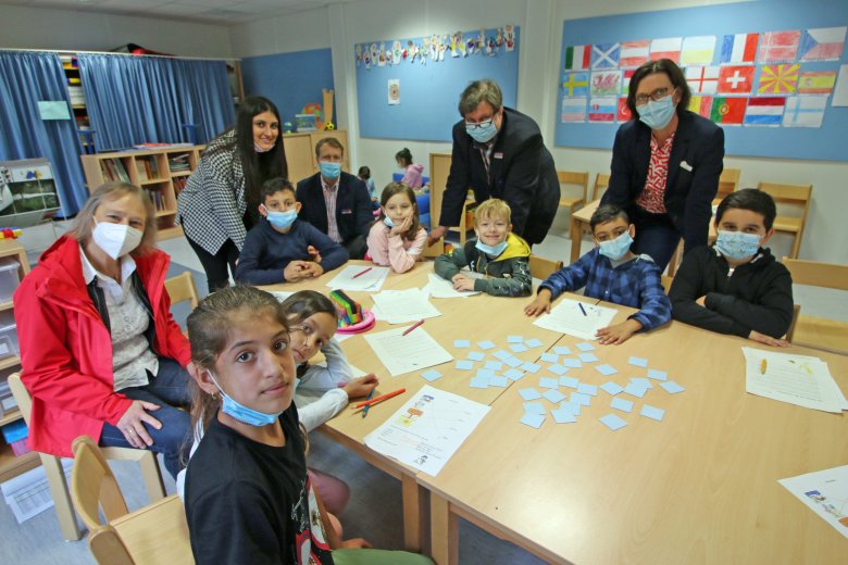 Pressetermin in der Brüder-Grimm-Schule, in der zweiten Reihe schauen zu: Erika Dahlkötter (l.), Sandra Jürgenhake (r.), Axel Hemminghaus (2.v.r. ) und Andrè Mannke besuchen den Ferienkurs, in dem die Studentin Revana Khibo (2.v.l.) gerade unterrichtet. 