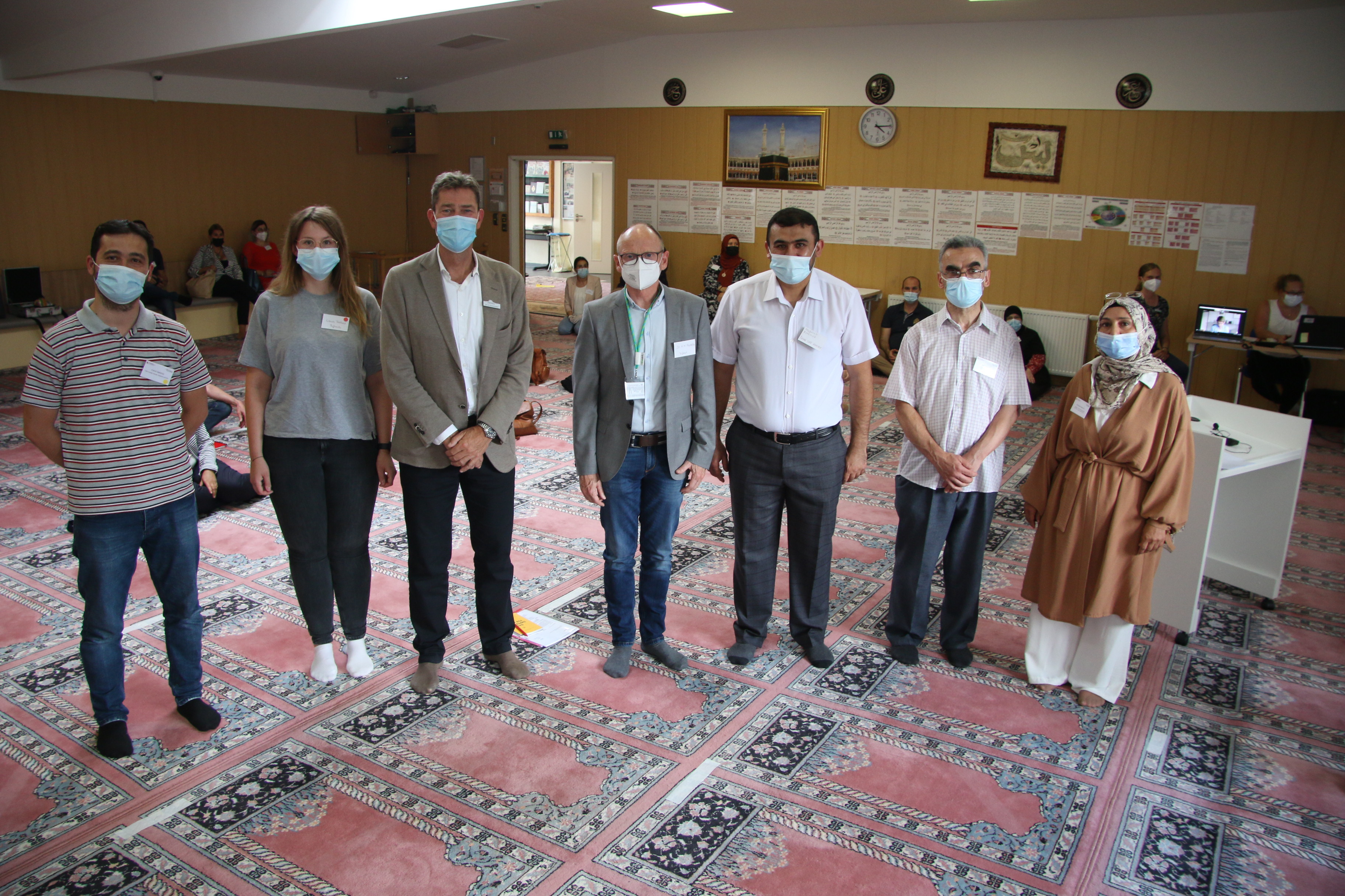 (v.l.) Cemil Sahinöz (Integrationsagentur DRK und Brückenbauer), Laura Fortkord (Abteilung Gesundheit des Kreises), Dr. Norbert Kreutzmann (Leiter Bildungsbüro), Dr. Michael Hanraths (ärztlicher Leiter Impfzentrum), Seyfullah Korkmaz (Imam), Arif Sönmez (Brückenbauer und im Vorstand des Türkisch-Islamischen Kulturvereins Rheda-Wiedenbrück) und Zübeyde Davulcu (stellvertretende Vereinsvorsitzende des Türkischen-Islamischen Kulturvereins) bei der ersten Präsenzveranstaltung des Projektes ‚Brückenbauer‘. (v.l.) Cemil Sahinöz (Integrationsagentur DRK und Brückenbauer), Laura Fortkord (Abteilung Gesundheit des Kreises), Dr. Norbert Kreutzmann (Leiter Bildungsbüro), Dr. Michael Hanraths (ärztlicher Leiter Impfzentrum), Seyfullah Korkmaz (Imam), Arif Sönmez (Brückenbauer und im Vorstand des Türkisch-Islamischen Kulturvereins Rheda-Wiedenbrück) und Zübeyde Davulcu (stellvertretende Vereinsvorsitzende des Türkischen-Islamischen Kulturvereins) bei der ersten Präsenzveranstaltung des Projektes ‚Brückenbauer‘.
