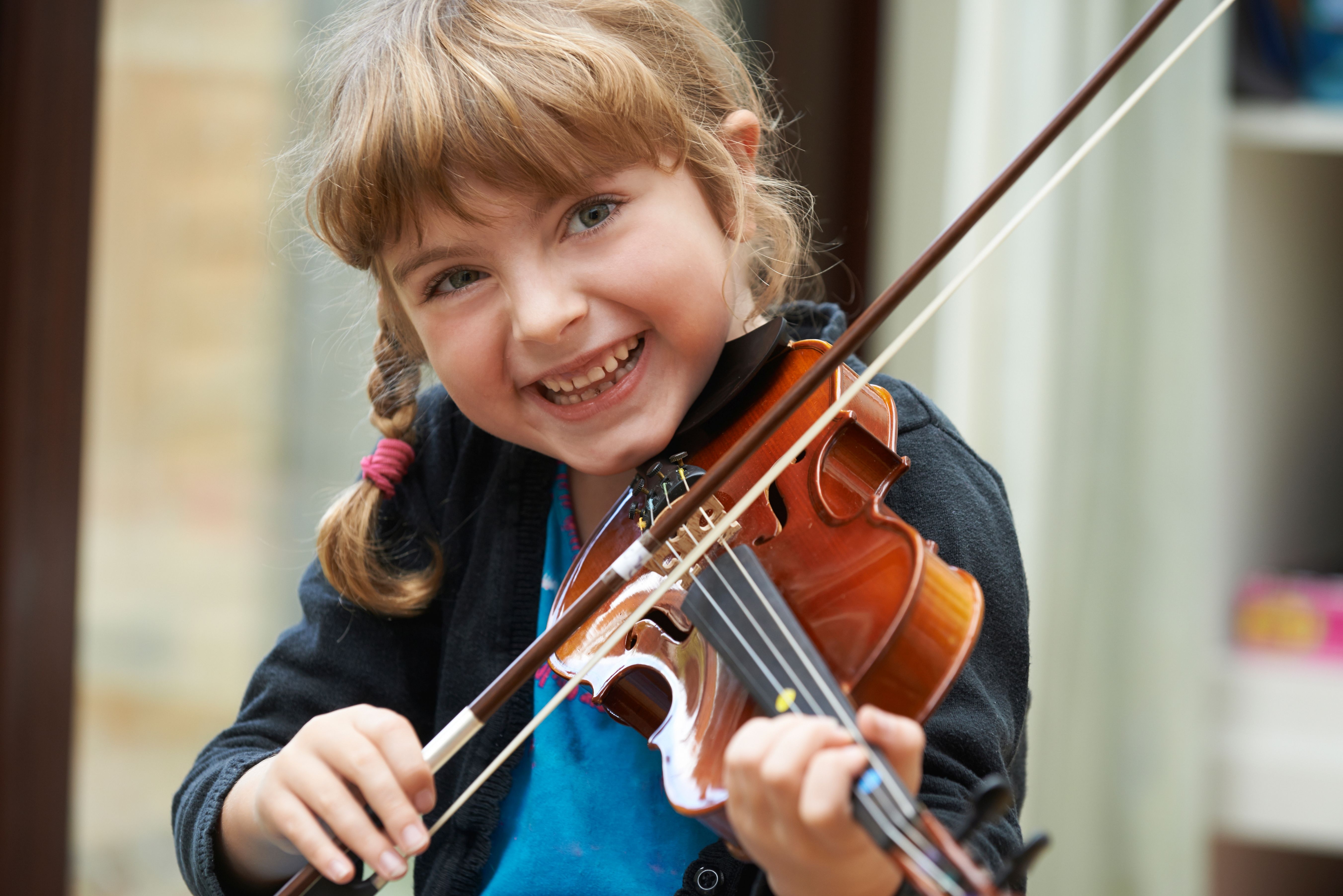 Portrait Of Young Girl Learning To Play Violin Kind mit Geige
