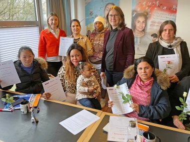 Ein Gruppenfoto mit mehreren Frauen und Kindern auf dem Schoß. 