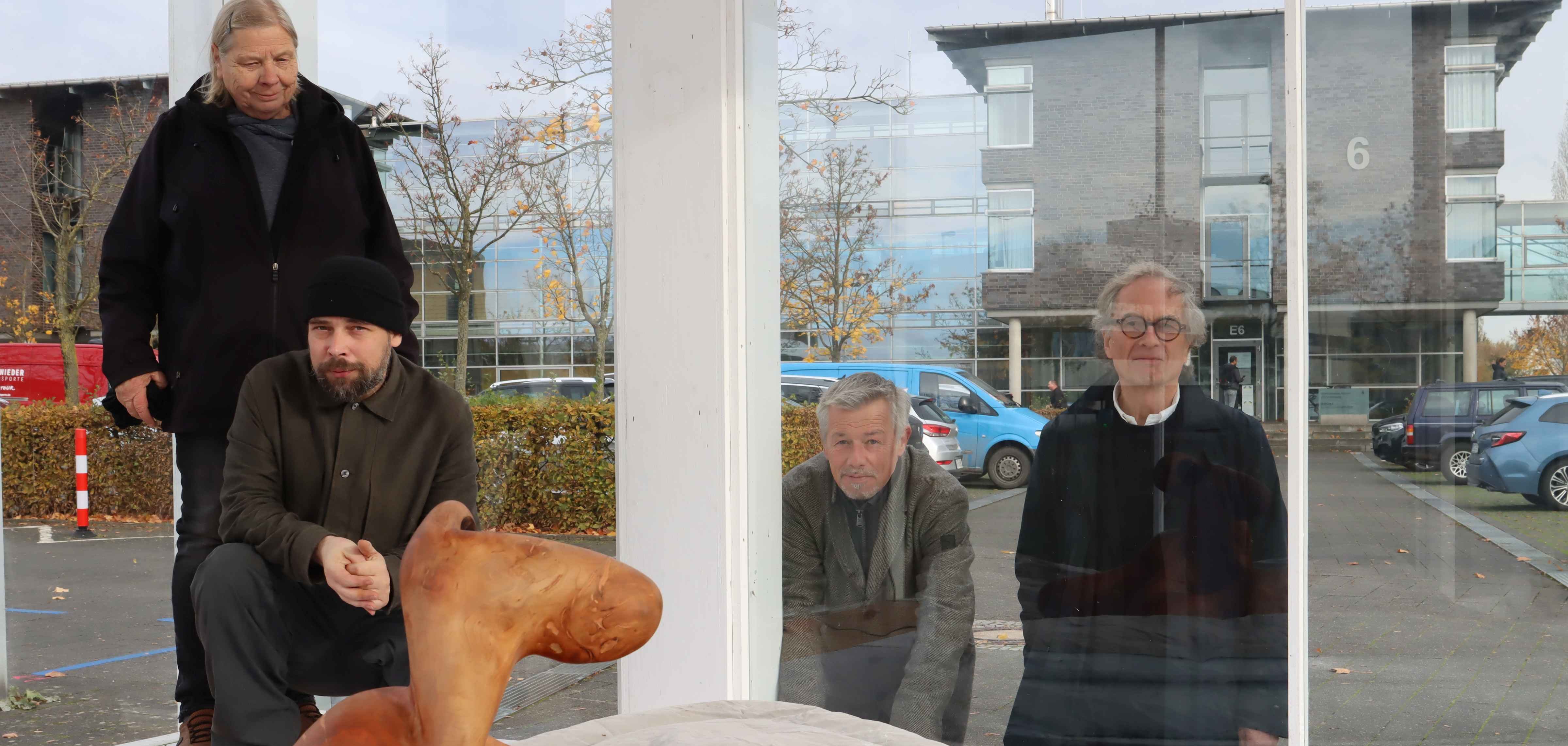 Im Kunstpavillon und jenseits der Scheibe: Rose Lichtenberger (l.) und ihr Sohn Grischa präsentieren gemeinsam im Pavillon vor dem Kreishaus Gütersloh eine Installation. Im Hintergrund Friedrich Wilhelm Schröder, Vorsitzender des Kunstvereins für den Kreis Gütersloh (r.) und Jan Focken (2.v.r.), Leiter Referats Presse, Kultur und Archiv Kreis Gütersloh. 