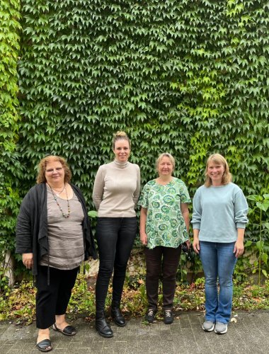 4 Personen stehen nebeneinander. 