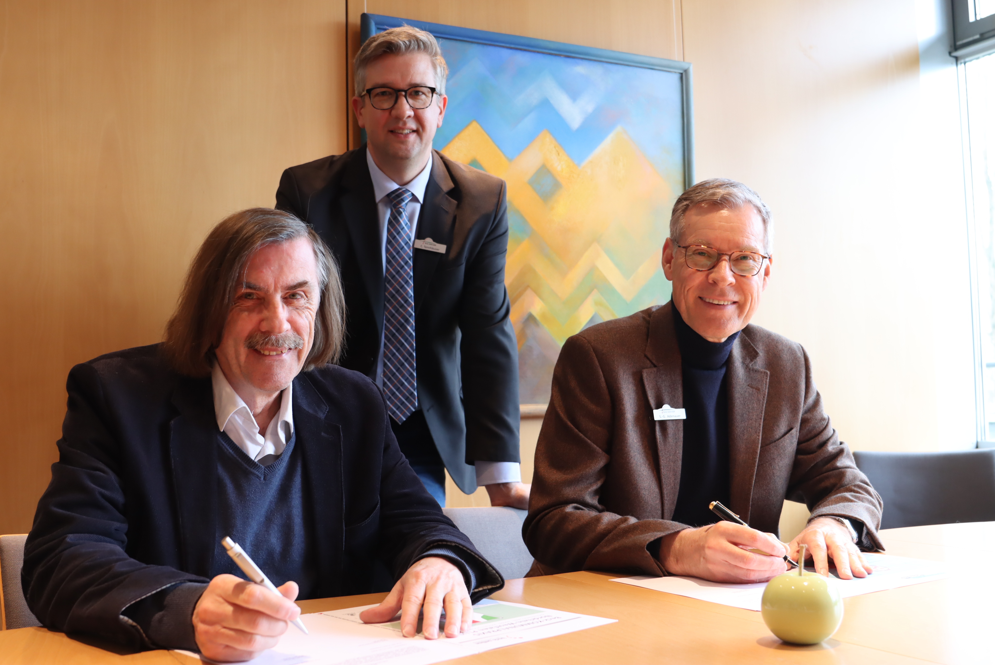 Bürgermeister Norbert Morkes, Carsten Tannhäuser und Landrat Sven-Georg Adenauer beim Unterschreiben