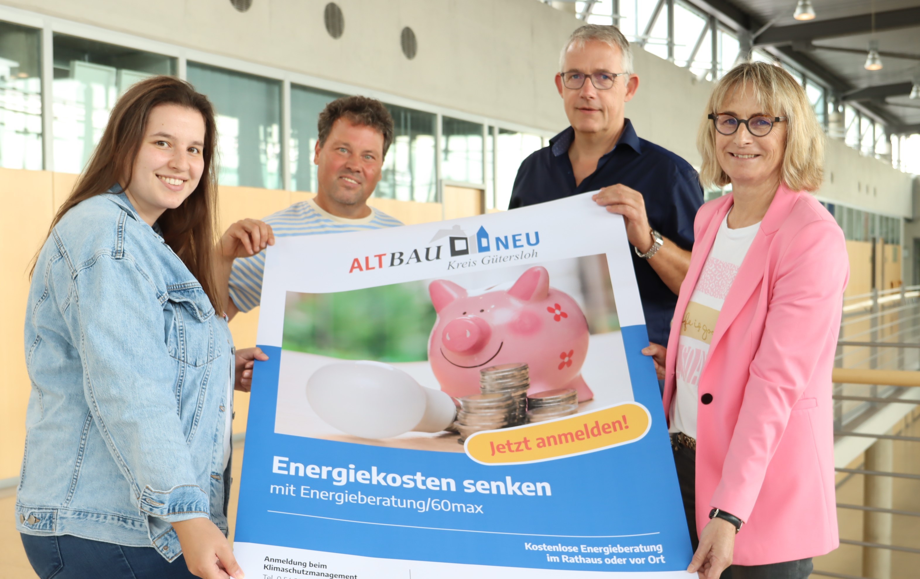 Bieten die 60-minütige Energieberatung an: (v.l.) Sabrina Löffler, Stadt Borgholzhausen, Energieberater Oliver Vredenburg, Klimaschutzmanager Dirk Nolkemper, Stadt Borgholzhausen, und Ulla Thering, Kreis Gütersloh. 4 Personen stehen im Foyer des Kreishauses Gütersloh und halten ein Werbeplakat in den Händen.