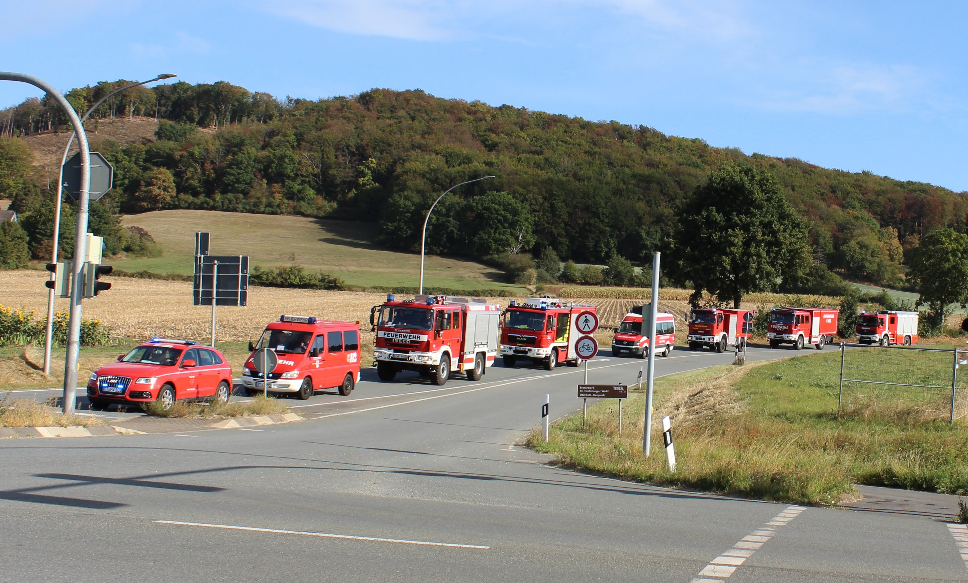 Mehrere Einsatzfahrzeuge der Feuerwehr stehen hintereinander an einer Ampelkreuzung.