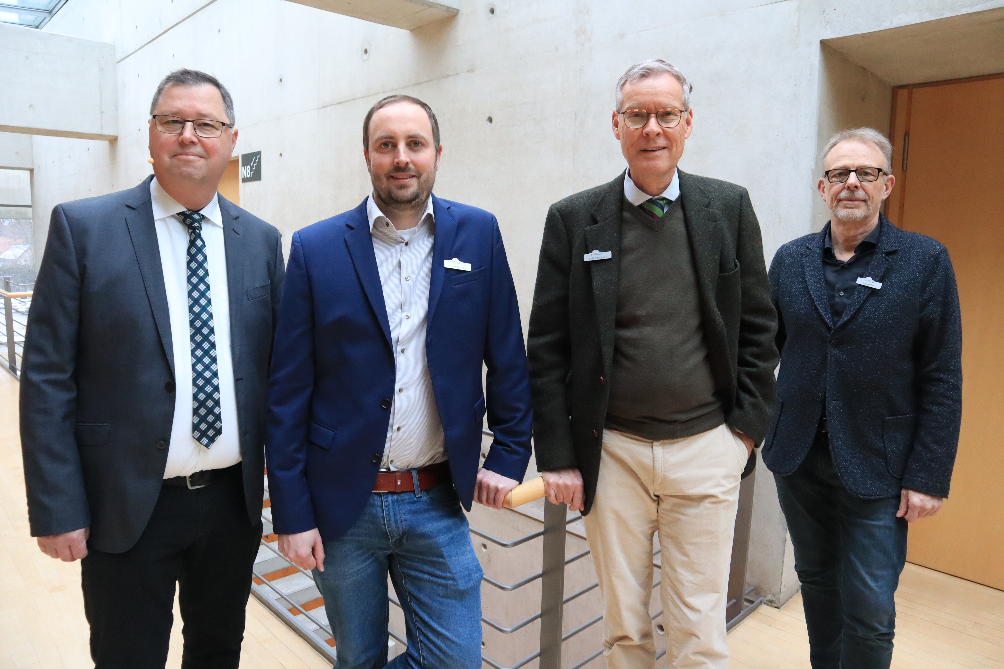 Vier Männer stehen in einer Reihe im Kreishaus Gütersloh.