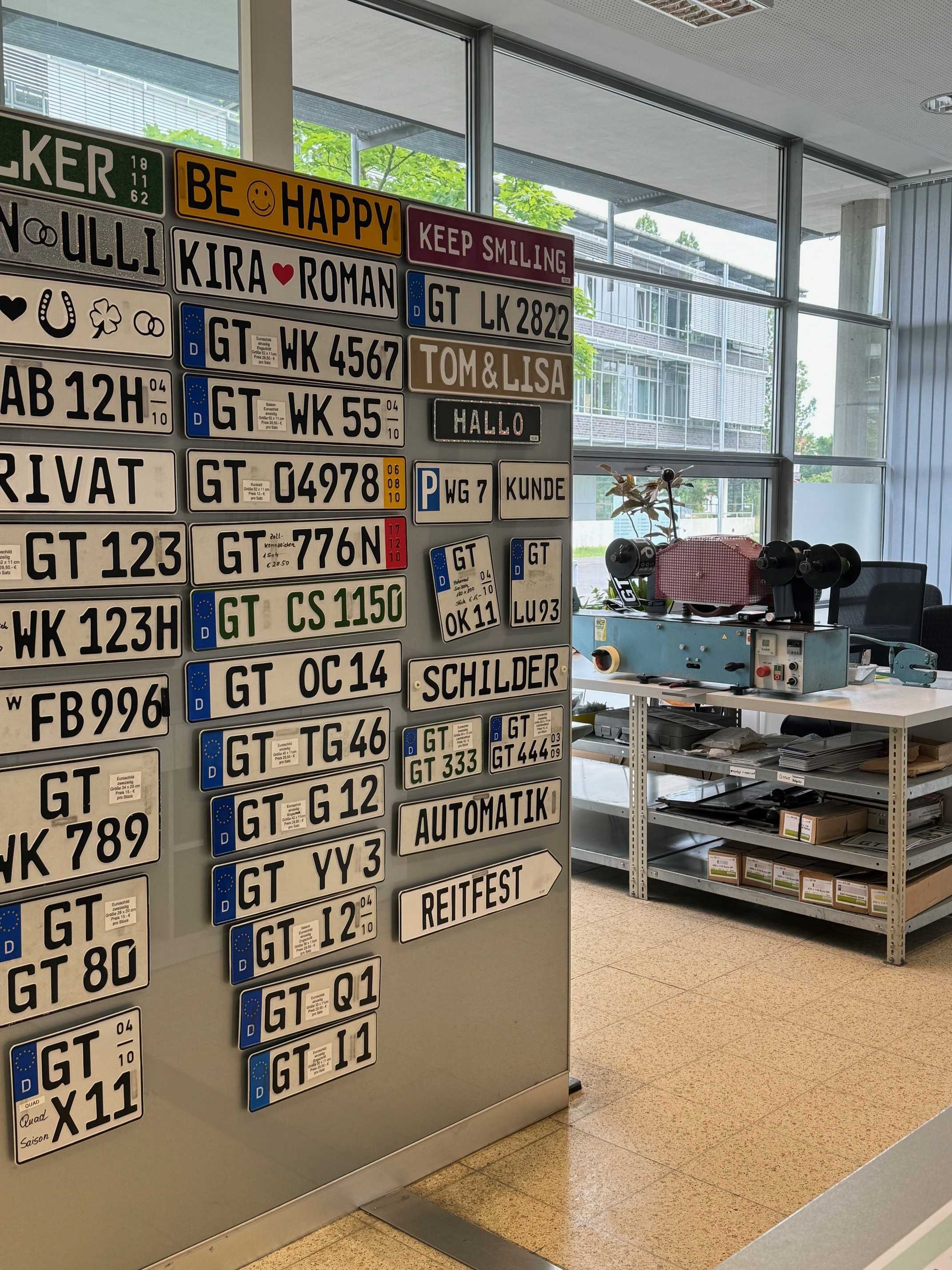 Ein Blick in den Innenraum der Schilderstelle, wo Musterschilder an der Wand hängen.