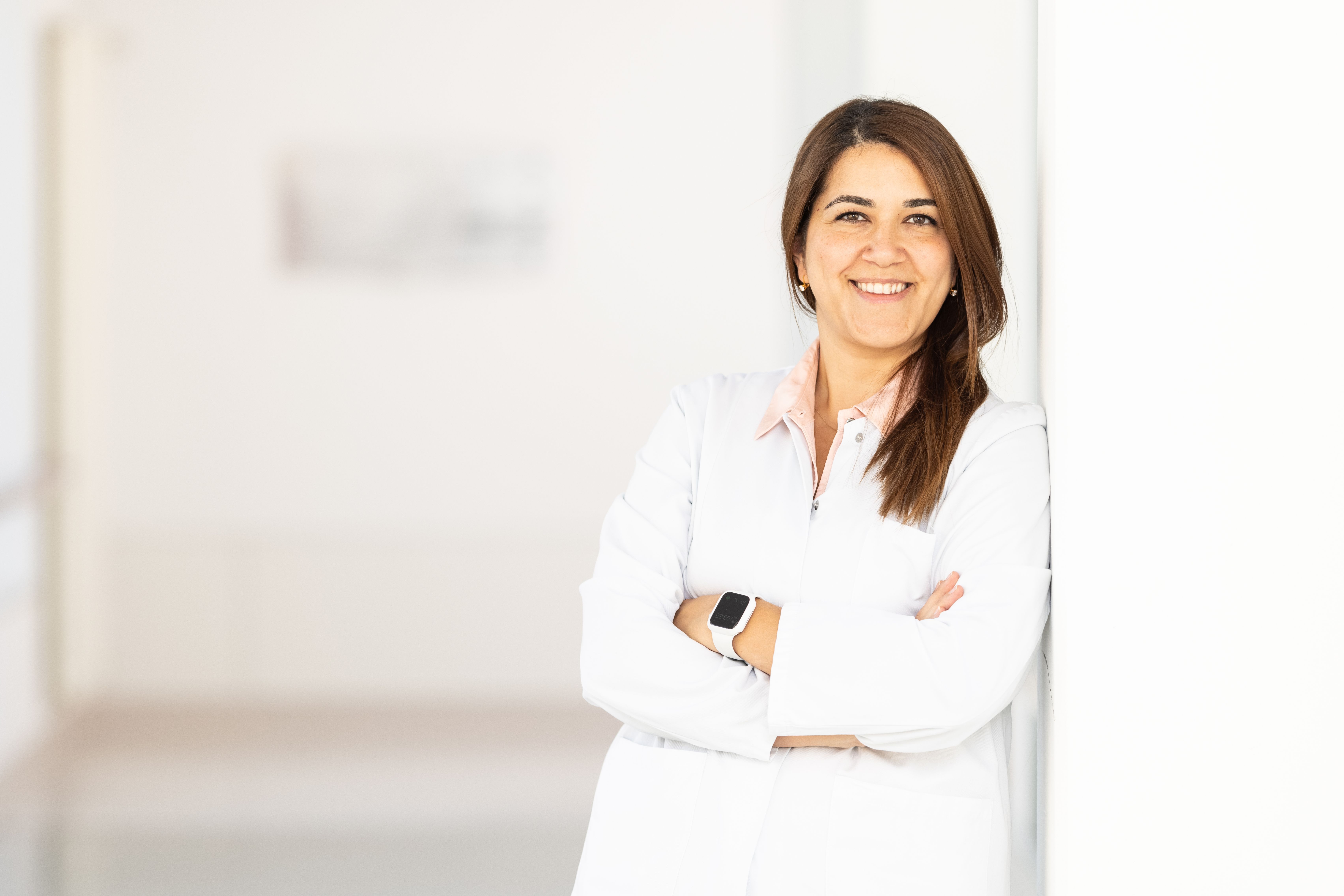 Frau mit verschränkten Armen an die Wand gelehnt.