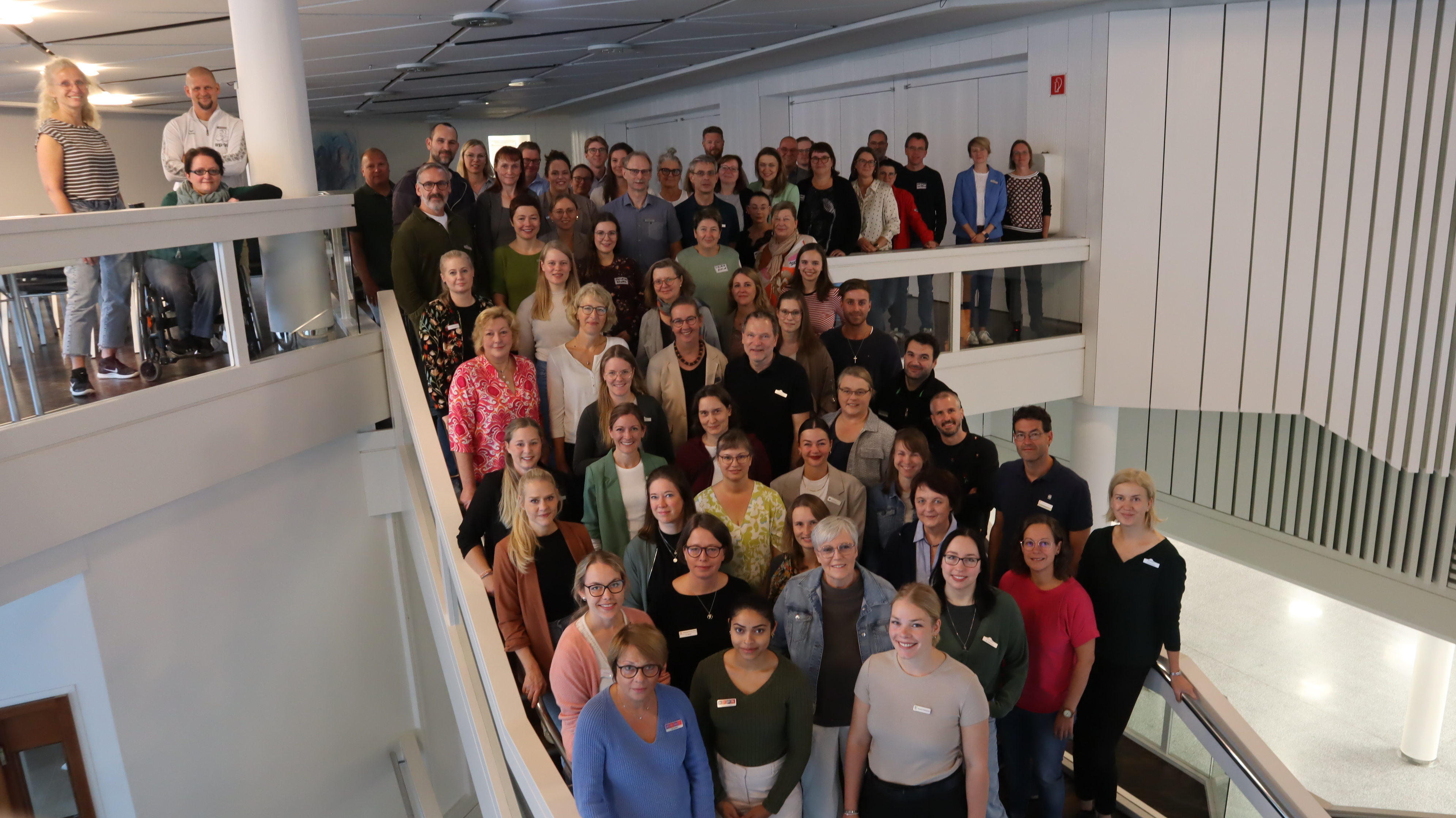 Die Mitglieder des Arbeitskreises stehen auf der Treppe in der Stadthalle Gütersloh