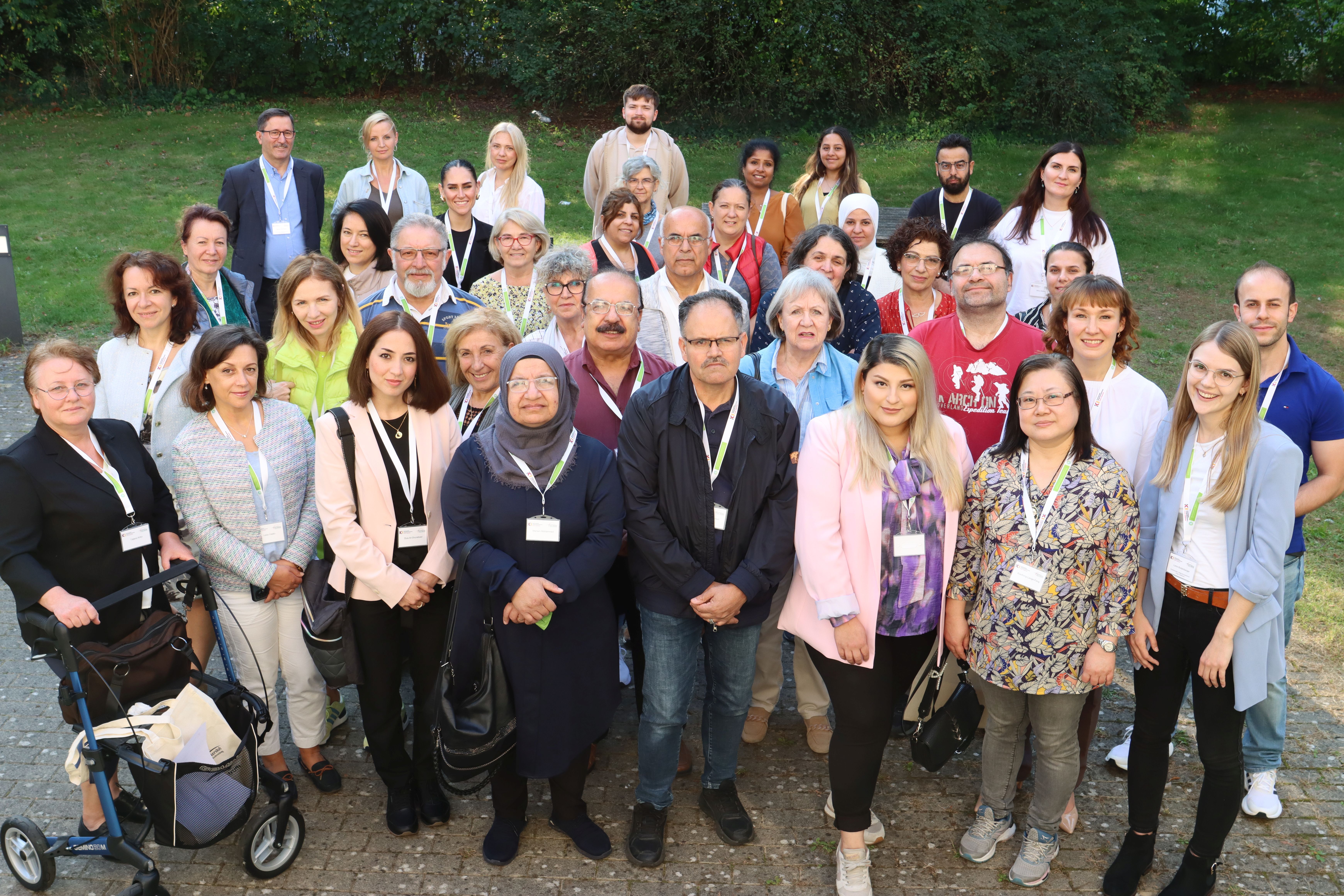 Auf dem Bild steht eine Gruppe von ca. 50 Menschen auf einem Rasen.