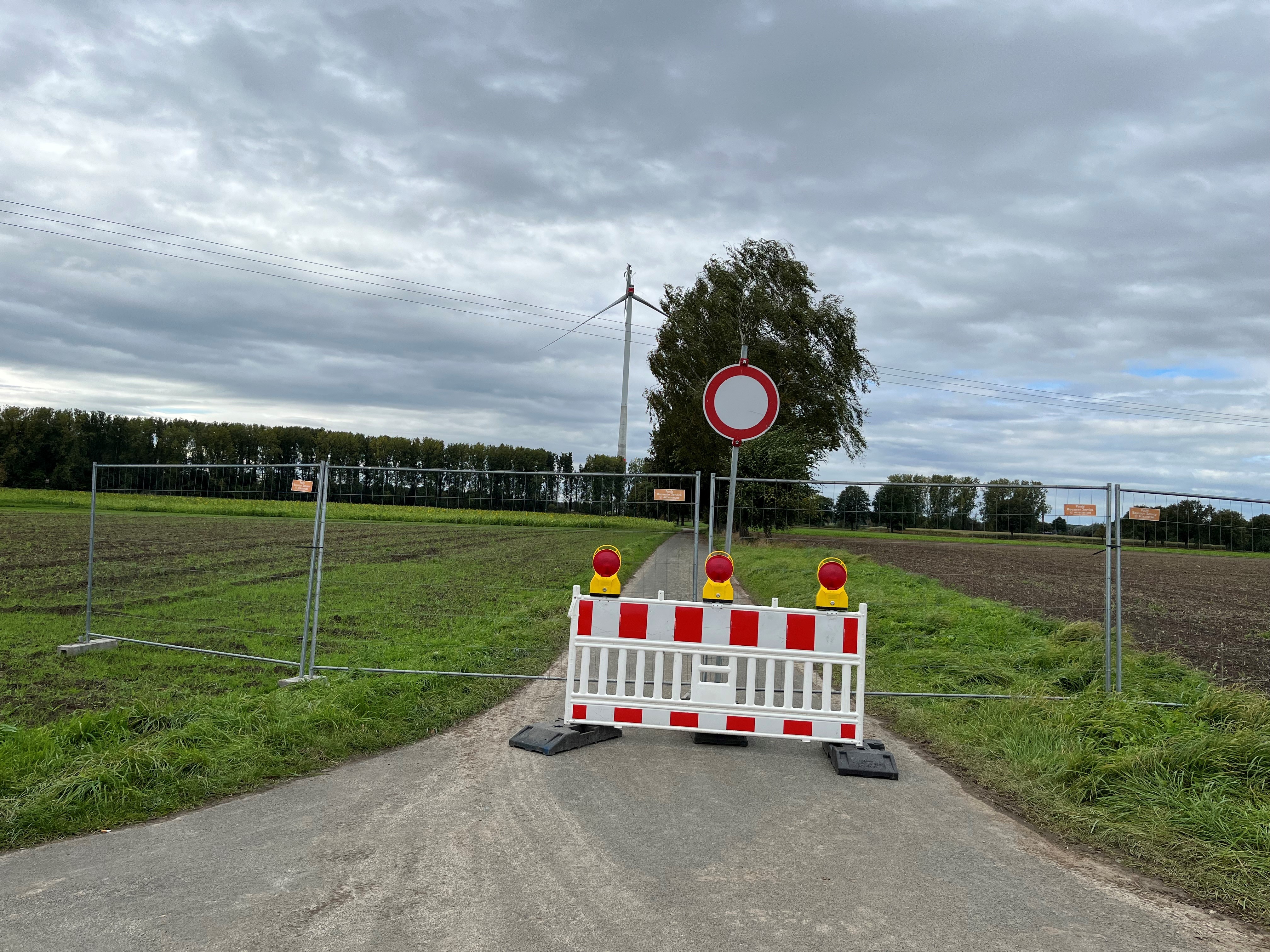Absperrung auf einem Weg rund um die beschädigte Windenergieanlage. Vor der beschädigten Windenergieanlage in Langenberg stehen Abspeerbaken auf der Straße. Der Bereich darf nicht betreten werden.