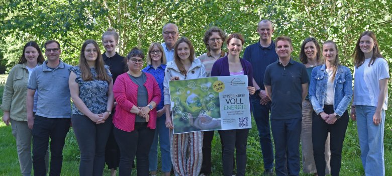 Gruppe aus mehreren Personen, einige halten ein Plakat in den Händen.