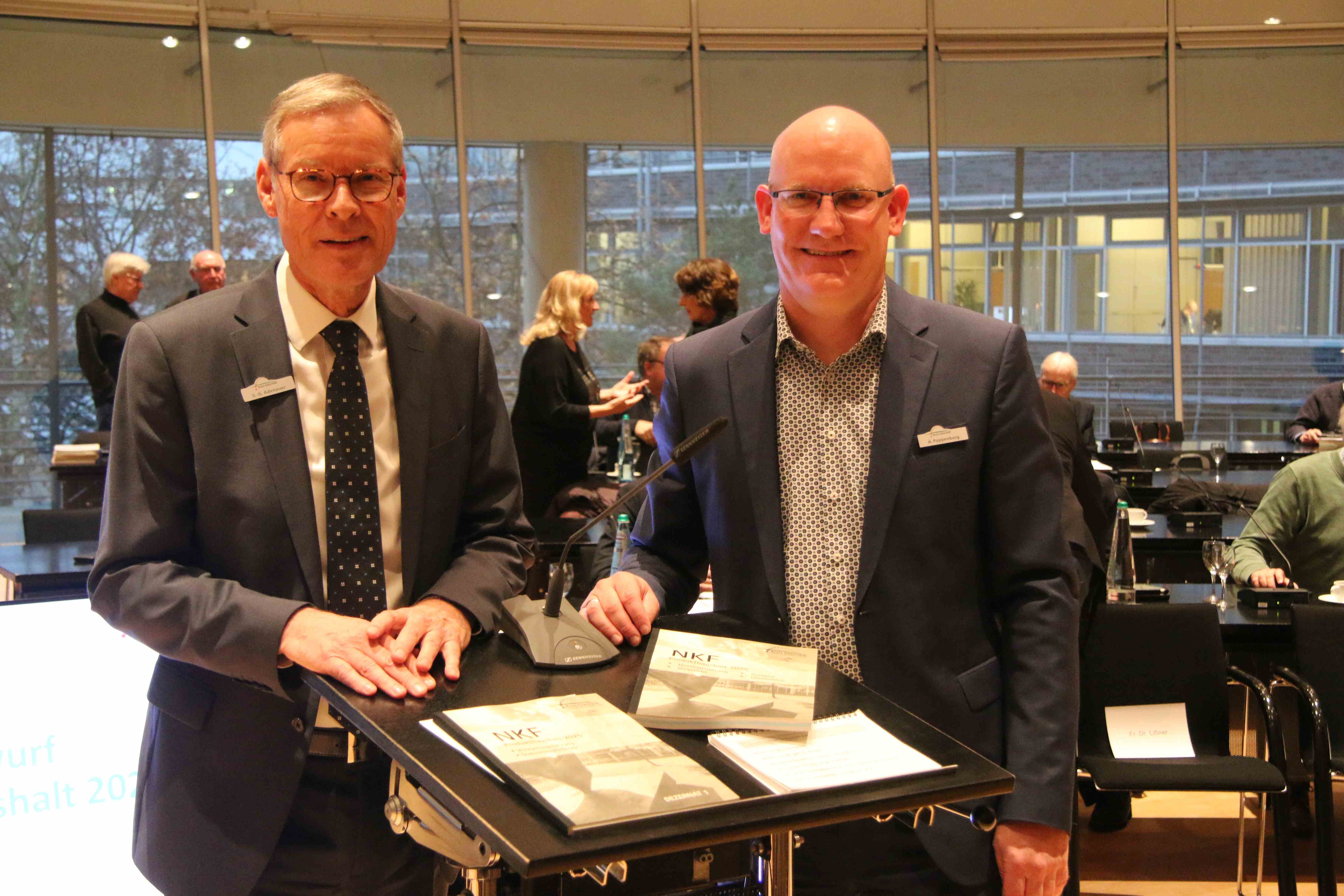 Haushaltseinbringung für den Haushalt 2025 in den Kreistag Landrat Sven-Georg Adenauer und Kämmerer Andreas Poppenborg im großen Sitzungssaal des Kreishauses Gütersloh am Rednerpult. Auf dem Rednerpult zwei Bände des Haushaltsentwurfs.