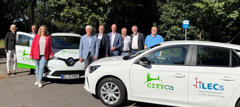 Projektpartner stehen an den zwei E-Autos.