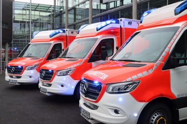 Die drei neuen Rettungswagen mit eingeschaltetem Blaulicht vor dem Kreishaus in Gütersloh