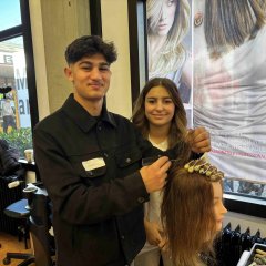 Zwei Personen mit einer Frisierpuppe