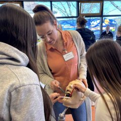 Drei Personen mit einer Zahnarzt-Demopuppe