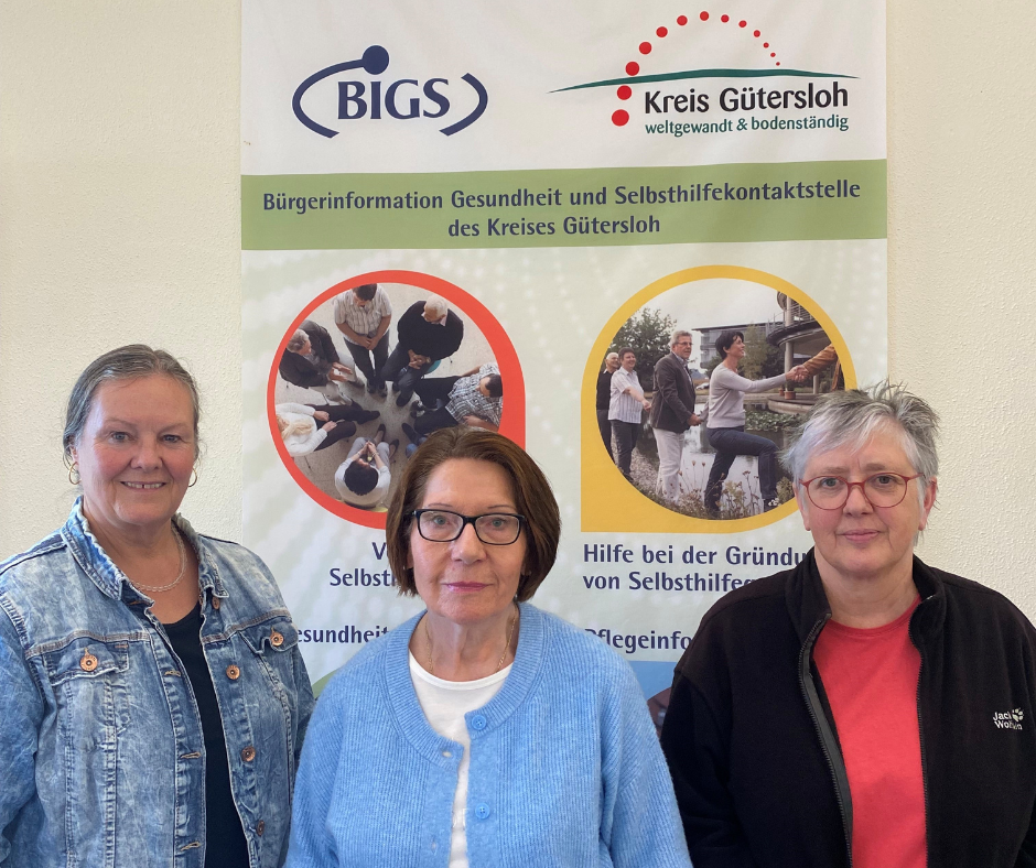 Drei Personen vor einem Infobanner