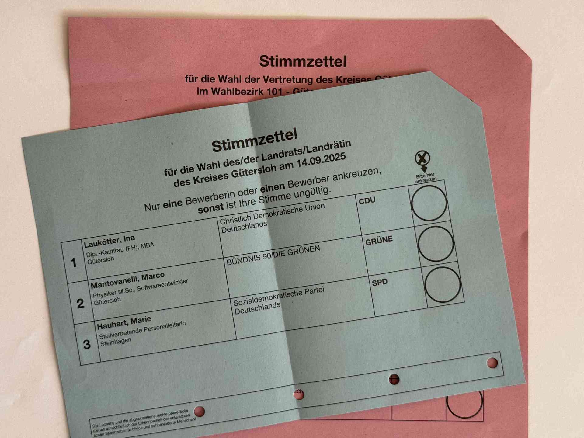 Stimmzettel in blau für Landrats- und verdeckt in rot für Kreistagswahl