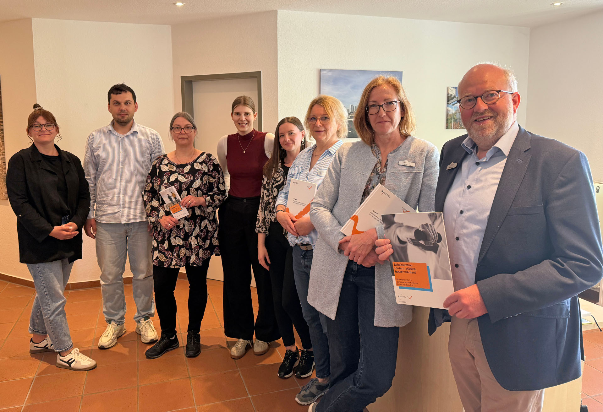 Personen stehen nebeneinander und halten teilweise Infomaterial in den Händen. 