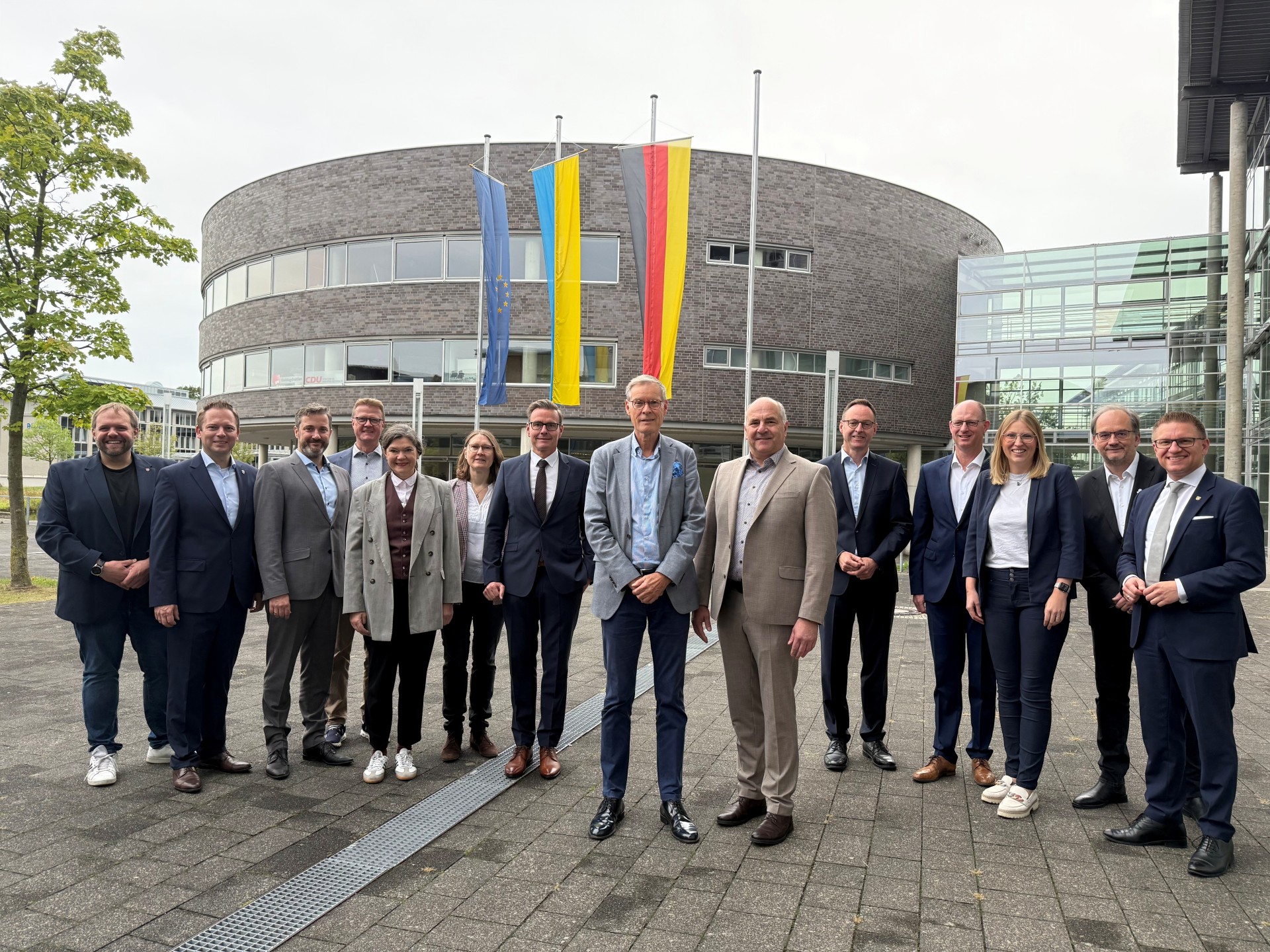 Landrat und Bürgermeisterinnen sowie Bürgermeister vor der Rotunde am Kreishaus Gütersloh.
