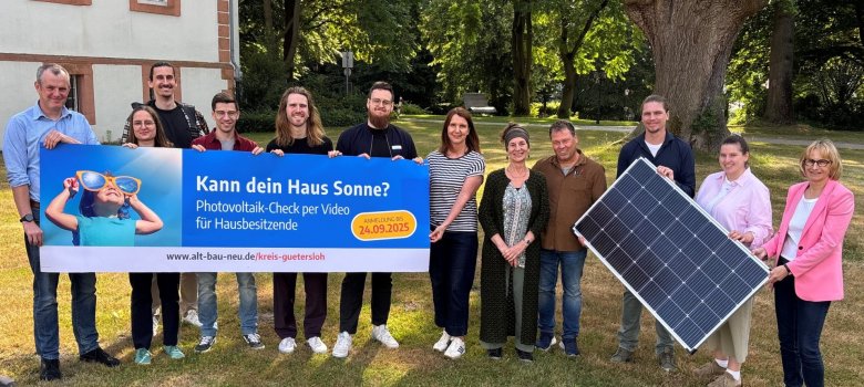 Personen stehen nebeneinander und halten Plakate und Banner in den Händen. 