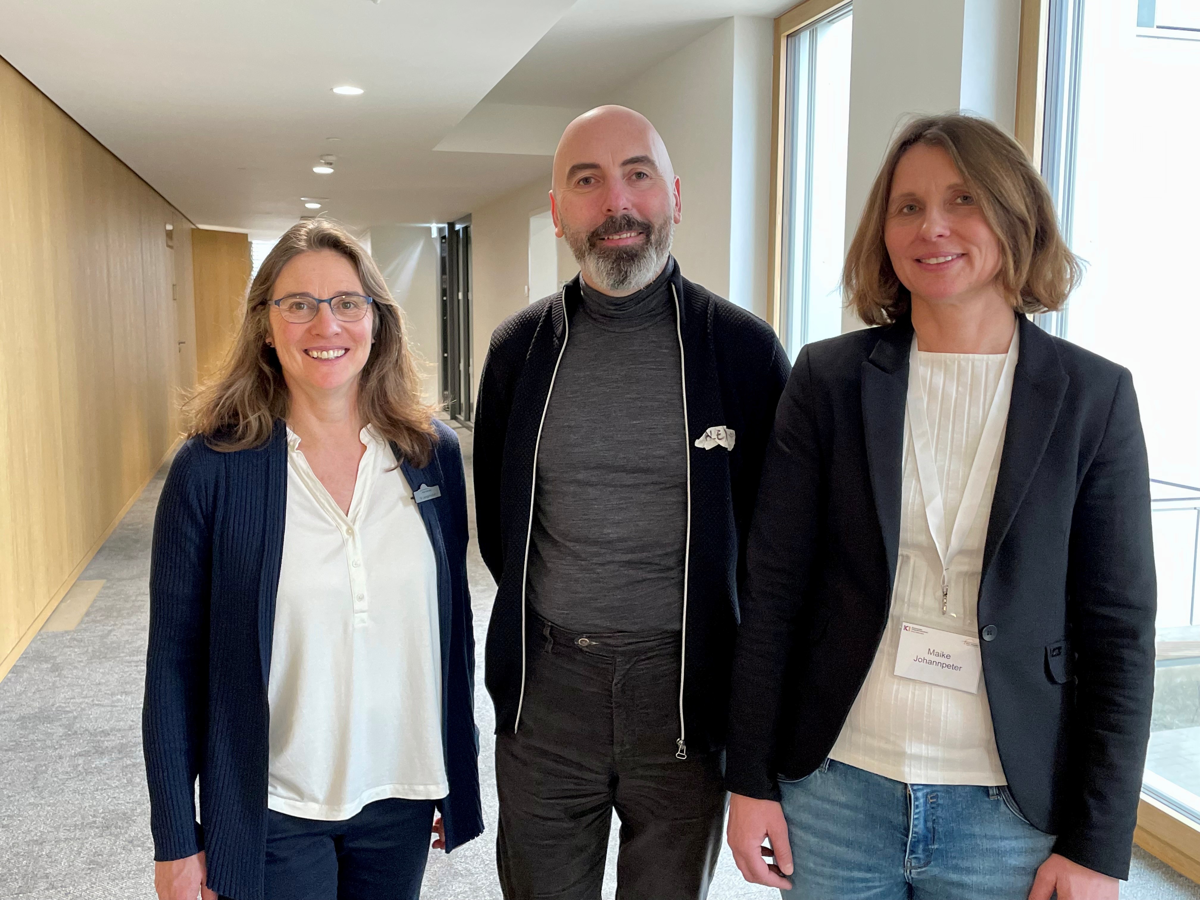 Zwei Frauen und ein Mann stehen nebeneinander und blicken in die Kamera.