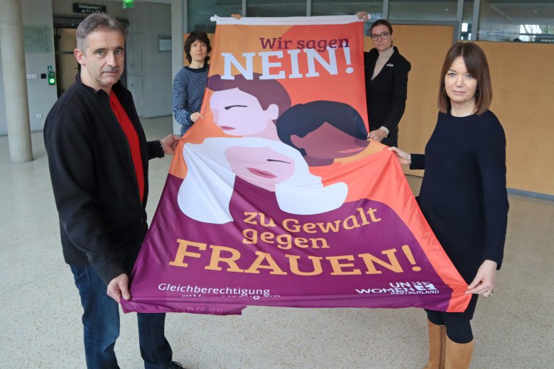 Personen halten eine Fahne in der Hand.