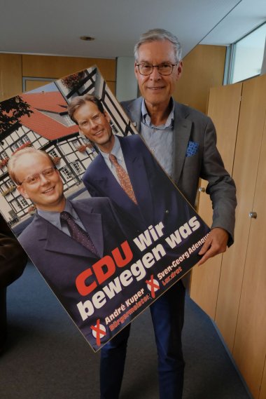 Ein Mann mit einem Wahlplakat im Büro