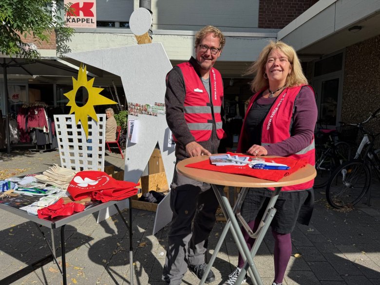 Zwei Menschen an einem Infostand