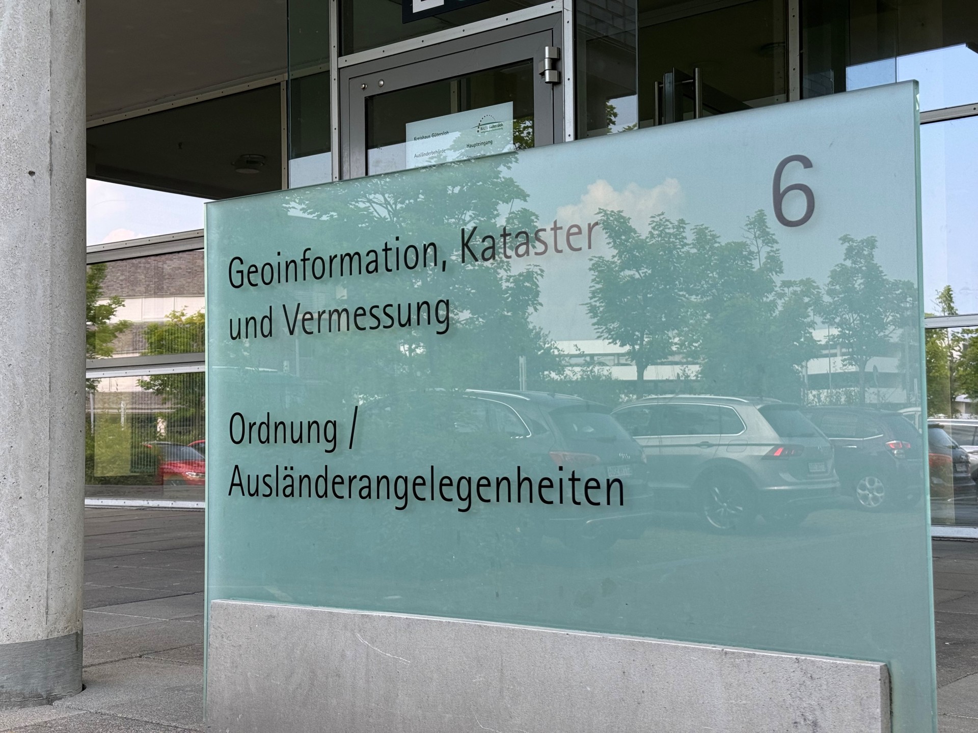 Glashinweisschild unter anderem zur Ausländerbehörde