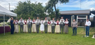 Eine Gruppe Tänzer steht auf einem Rasen 