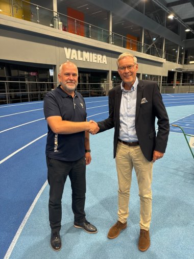 Zwei Männer geben sich die Hand in einem Stadion