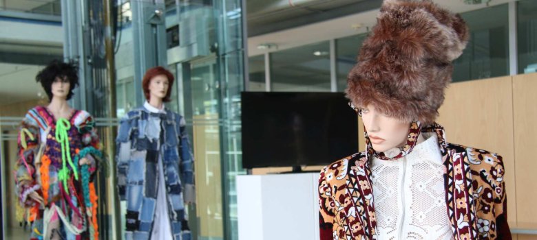 Drei Schaufensterpuppen mit Entwürfen von den Schülerinnen und Schülern der Design- und Kunstschule Valmiera.