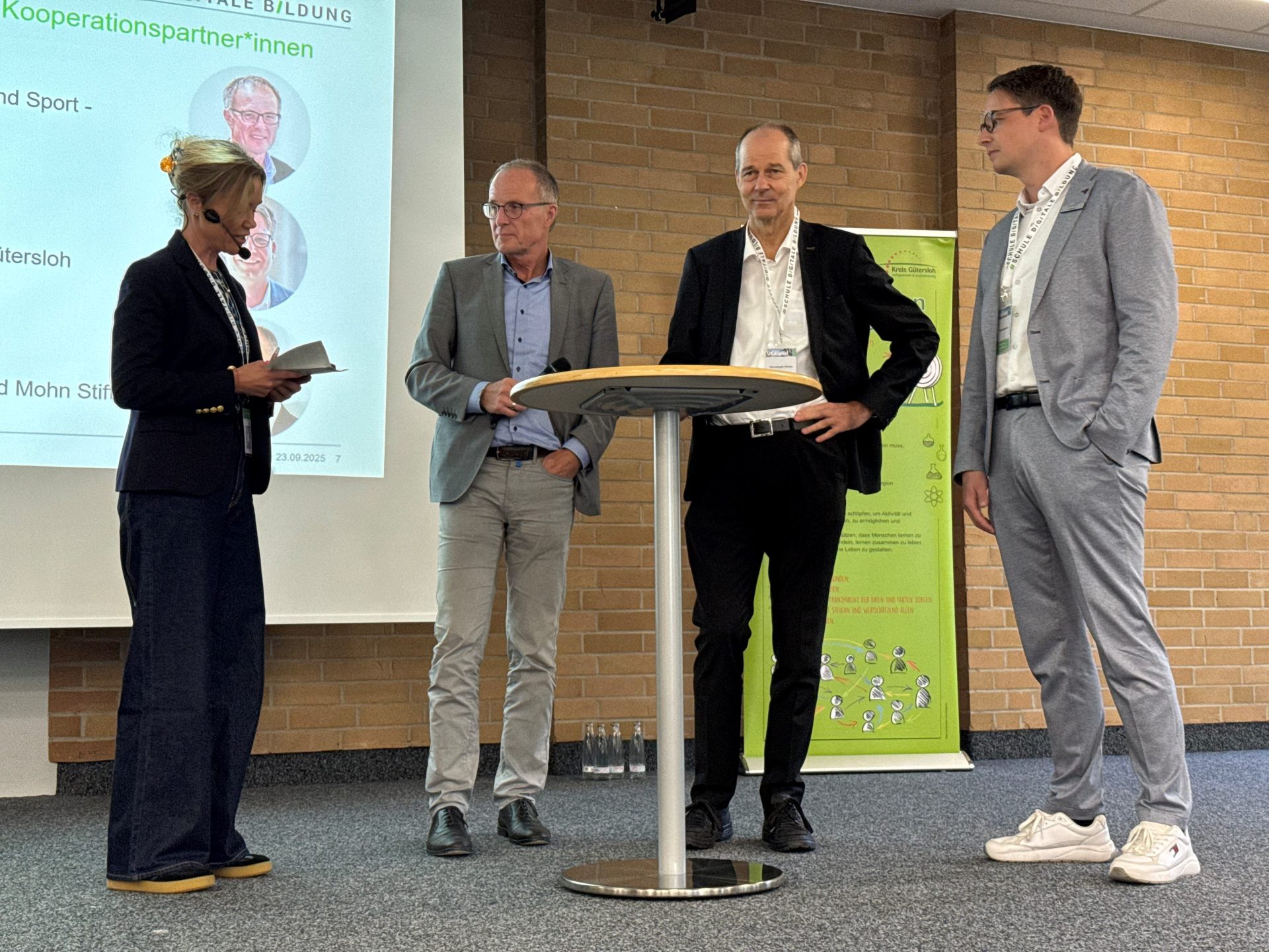 Moderatorin Julia Ures interviewte auf der Bühne des Berufsschulzentrums Rheda-Wiedenbrück unter anderem (v.l.) Michael Uhlich (Leiter der Abteilung Schule Bezirksregierung Detmold), Christoph Mohn (Vorstandsvorsitzender der Reinhard-Mohn-Stiftung) und Thomas Becker (Abteilungsleiter Bildung Kreis Gütersloh).  