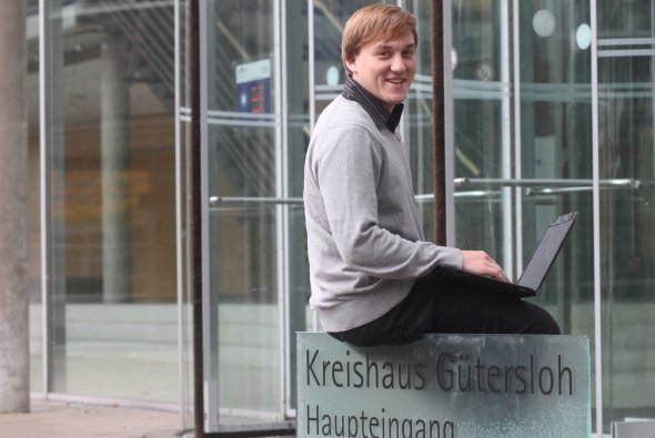 Jan Rugge-Fechtelpeter mit Laptop vor dem Kreishaus in Gütersloh