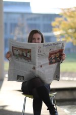 Leonie Bartsch schaut über den Zeitungsrand