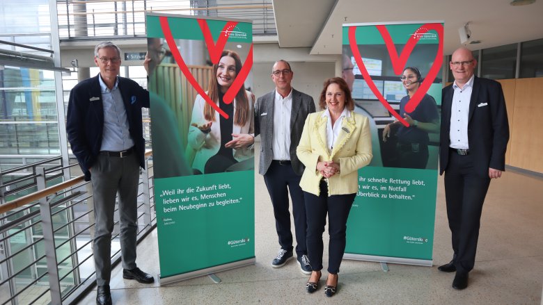 Die Projektverantwortlichen stehen zwischen den Roll-Ups zur Arbeitgebermarke im Foyer des Kreishauses Gütersloh.