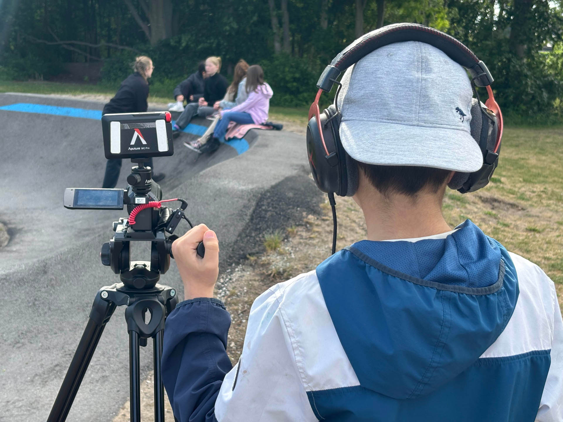 EIn Kind filmt eine Gruppe in einem Skatepark