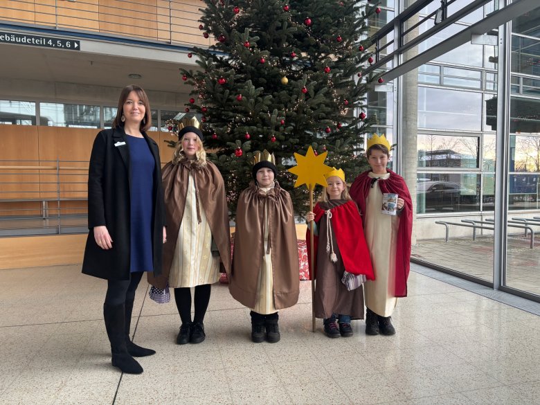 EIne Frau und vier Kinder vor einem Weihnachtsbaum im Kreishaus Gütersloh.
