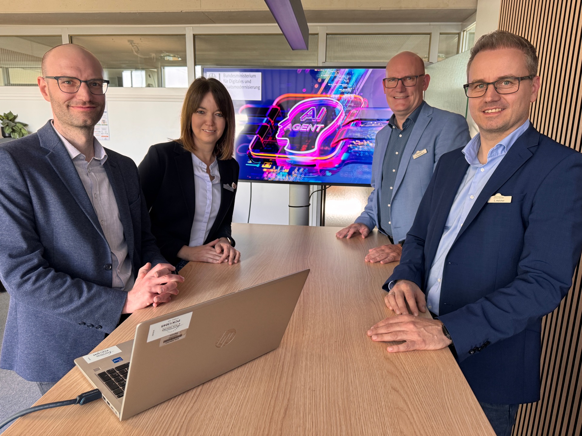 Ki- und Ditialisierungsstrategie / Agentic AI Hubs (v.l.): Marco Kerber (Projektleiter der KI- und Digitalisierungsstrategie), Landrätin Ina Laukötter, Andreas Poppenborg (Dezernent Personal, Finanzen und Zentrale Dienste) sowie Christian Melcher (Abteilungsleiter IT, Digitale Lösungen und Zentrale Dienste) vor einem Bildschirm mit dem Logovon Agentic AI Hubs.