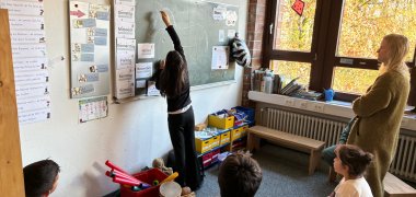 Kinder malen an der Tafel.